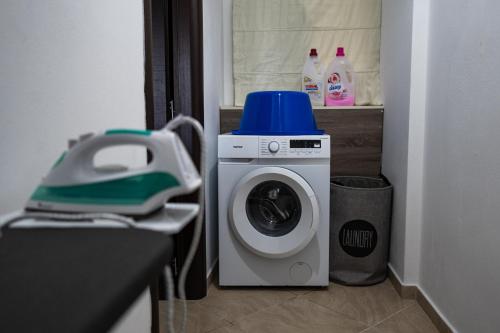 a washing machine with a blue top sitting in a room at Τα ανετα διαμμερισματα του Λεκα Α2 in Zakharo
