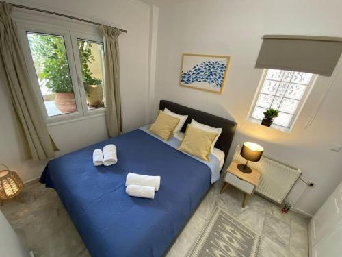 a bedroom with a blue bed with towels on it at Mermaid apartment Nafplio in Nafplio