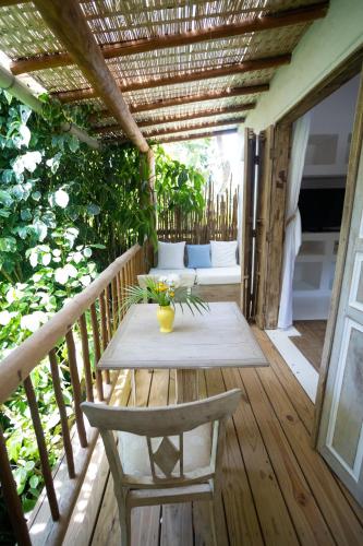 a wooden deck with a table and chairs on it at Santa Fe Casas Hotel Trancoso in Trancoso