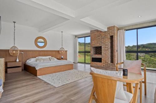 a bedroom with a bed and a table and a fireplace at Finca Encanto in Calimita