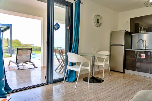 a kitchen with a table and chairs and a refrigerator at La Perle du Cap in Case-Pilote