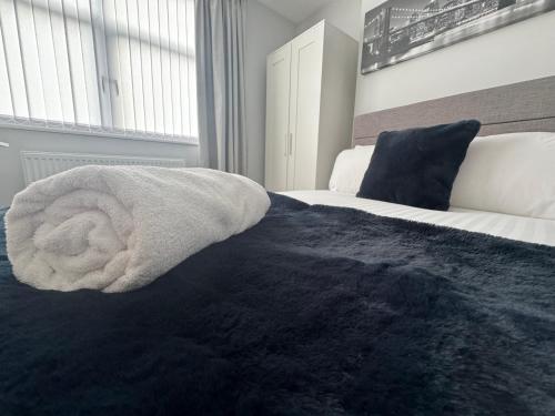 a bedroom with a bed with a towel on it at LYMM LIVING in Warrington