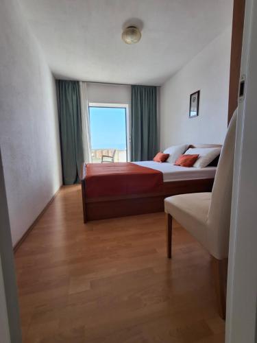 - une chambre avec un lit et une grande fenêtre dans l'établissement Apartment Irena Bol, à Bol