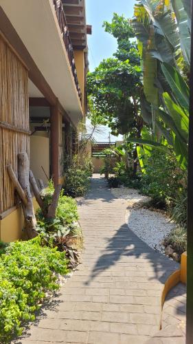 a walkway next to a building with trees and plants at Casa Majagua in Brisas de Zicatela