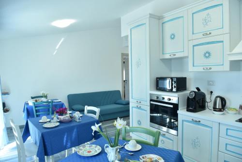 a kitchen with a table with a blue table cloth at Rosa dei Venti ROOMS in Abbasanta