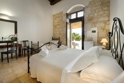 a bedroom with a bed and a table and a desk at Baglio donna Concetta in Noto