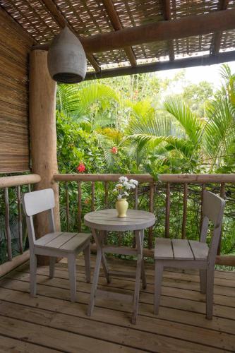 a table and two chairs on a wooden deck at Santa Fe Casas Hotel Trancoso in Trancoso