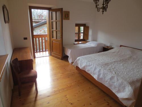 a bedroom with two beds and a wooden floor at Casa del Calzolaio - Dobar Suostar in Stregna