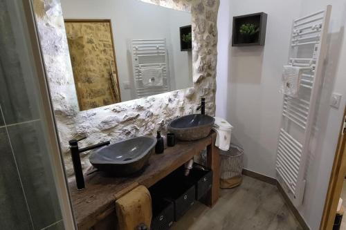 a bathroom with two sinks and a large mirror at La Romarine in Chauzon