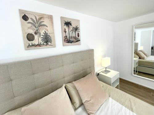 a bedroom with a bed with two pictures on the wall at Benidorm Old Town House with lounge area in Benidorm