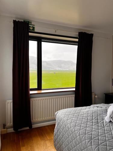 sypialnia z łóżkiem i dużym oknem w obiekcie Hotel Skógá by EJ Hotels w mieście Skógar