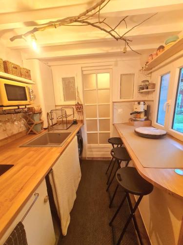une cuisine avec un évier et un comptoir avec des tabourets dans l'établissement Appartement, atelier d'artiste, à Chelles