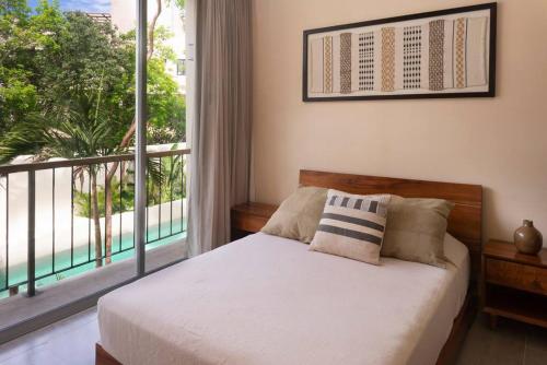 Un dormitorio con una cama y una ventana grande. en Modern Studio w Balcony & Pool La Veleta, - Tulum - A207, en Tulum