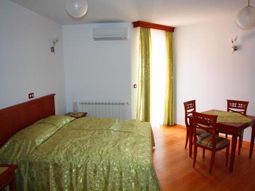1 dormitorio con 1 cama, mesa y sillas en Villa Armin, en Rovinj