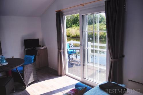 a room with a sliding glass door with a balcony at BestMarine Waterchalets Flevo Marina in Lelystad