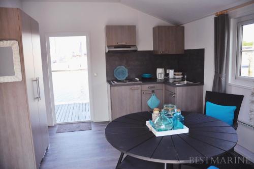 a small kitchen with a table in a room at BestMarine Waterchalets Flevo Marina in Lelystad