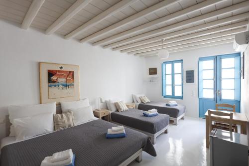 a white room with two beds and a couch at Mykonos Pantheon in Kalo Livadi