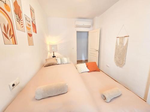 贝莱斯德韦瑙达利亚Pura Vida - Terraza, Piscina, Playa 15mn, Sierra的一间白墙房间里有两张床