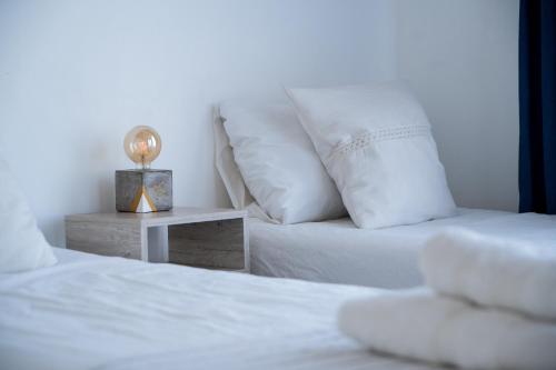 a bed with white sheets and pillows next to a table at Paso Calmo in Villa General Belgrano