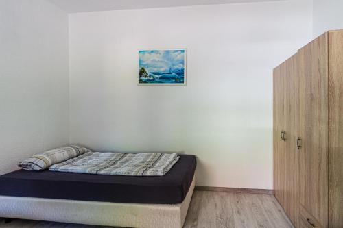 a bed in a room with a picture on the wall at Monteurwohnung in Rötha in Rötha
