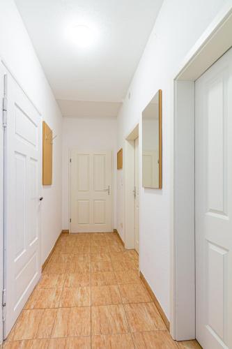 an empty hallway with white walls and wood floors at Monteurwohnung in Rötha in Rötha