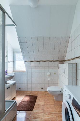 a bathroom with a toilet and a sink and a washing machine at Monteurwohnung in Rötha in Rötha