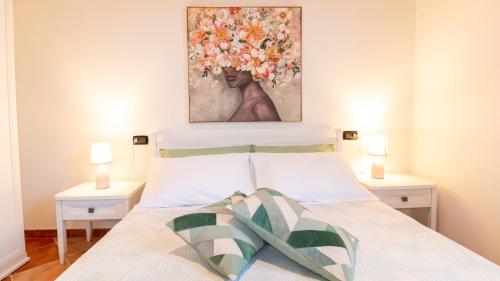 a bedroom with a bed with a painting on the wall at Sardinianworld - Domo Mea in Càbras