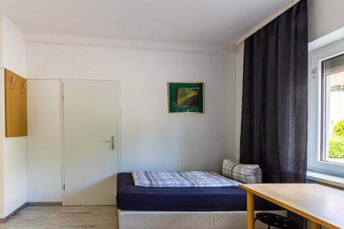 a small room with a bed and a window at Monteurwohnung in Rötha in Rötha