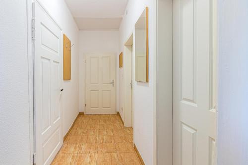 an empty hallway with white walls and wood floors at Monteurwohnung in Rötha in Rötha