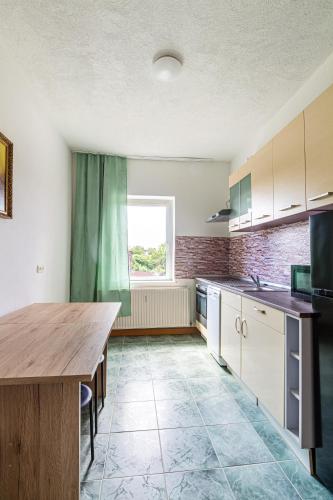 a kitchen with a wooden table and a window at Monteurwohnung in Rötha in Rötha