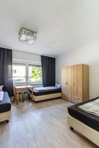 a bedroom with two beds and a desk and a table at Monteurwohnung in Rötha in Rötha