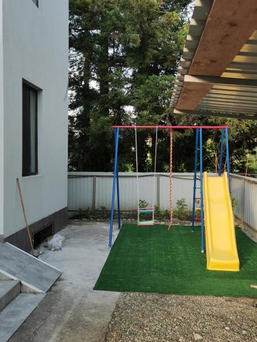 a playground with a yellow and blue swing at Solo apartments in Ureki