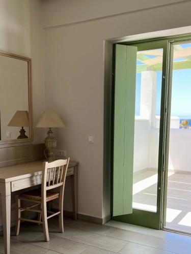 a room with a desk with a green sliding door at Alona Luxury Villas in Arkasa