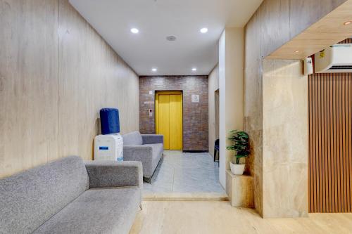 a hallway with couches and a yellow door at Townhouse 1343Oriental INN in Chennai