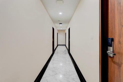 a long hallway with a white floor and a door at Townhouse 1343Oriental INN in Chennai