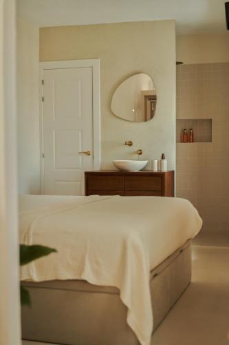 bagno con letto, lavandino e specchio di Casa Uva - Boutique Guest House a Vejer de la Frontera