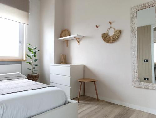 una camera bianca con letto e specchio di Kasakiwi Apartment a Vicenza