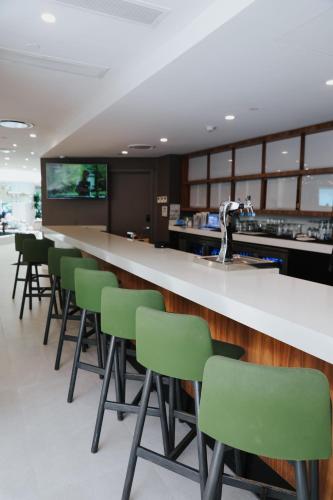a bar with green chairs in a waiting room at B Ocean Resort Fort Lauderdale Beach in Fort Lauderdale