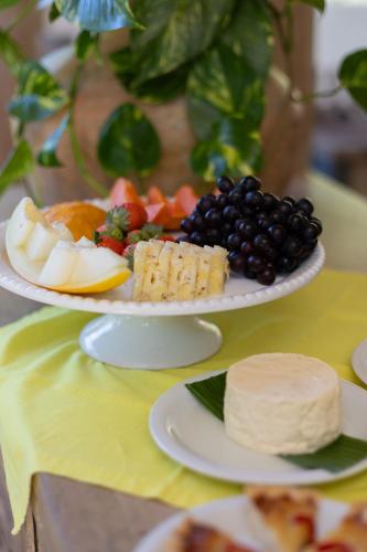 a plate of food with fruit and cheese on a table at Santa Fe Casas Hotel Trancoso in Trancoso