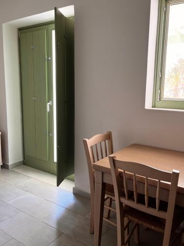 a dining room with a table and chairs and green cabinets at Alona Luxury Villas in Arkasa