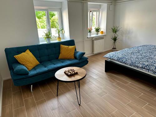 a living room with a blue couch and a table at Alpine Echo Apartments in Bovec