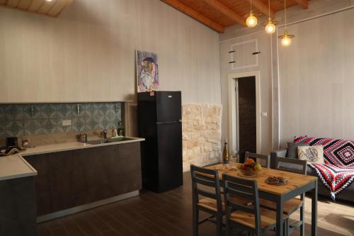 a kitchen with a table and a refrigerator in a kitchen at The Essence in Safed