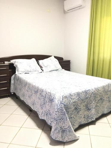 ein Schlafzimmer mit einem Bett mit einer blauen und weißen Decke in der Unterkunft Vista da Serra in Cavalcante