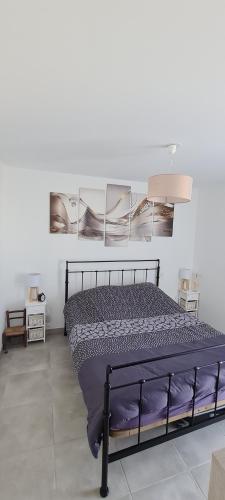 ナルボンヌ・プラージュにあるAppartement SUNSET LODGEの壁にポスターが貼られた黒いベッドのある寝室