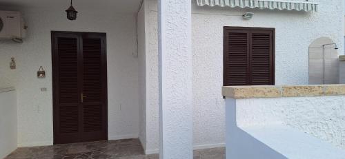 two brown doors on the side of a building at Villetta Lorena a Mancaversa in Marina di Mancaversa