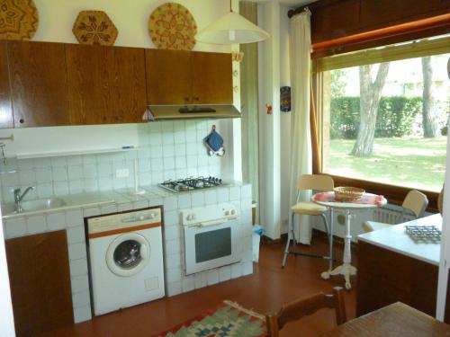 a kitchen with a stove and a washing machine at il geranio in Tirrenia
