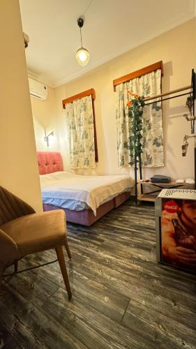 a bedroom with a bed and a chair in it at Callisto Pub & Kitchen & Hotel in Antalya