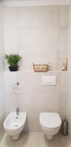 une salle de bain blanche avec des toilettes et un lavabo dans l'établissement Le Castille - à deux pas des plages, à Cannes