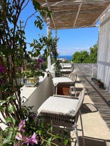 Villa Pasquale Capri في كابري: شرفة مع كراسي وإطلالة على المحيط