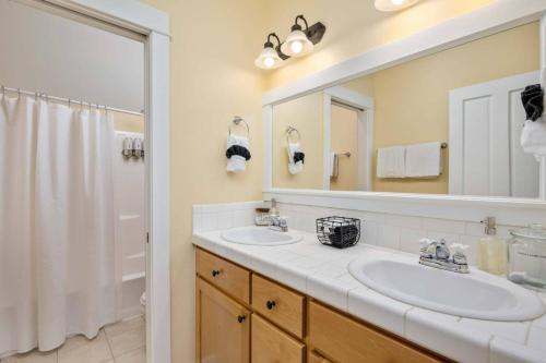 Un baño con dos lavabos y un espejo grande. en Ann and Kathy's Regal Seagull, en Lincoln City